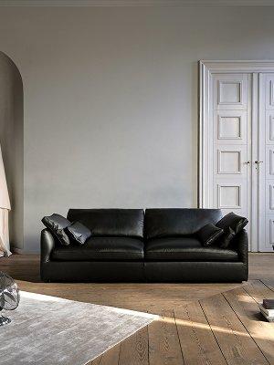 Modern living room with high ceilings, a Bellagio sofa in white Lazio fabric, a large window, and minimalist decor